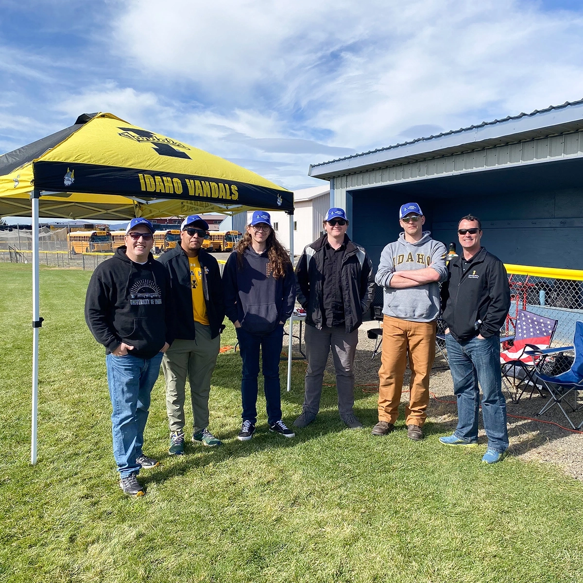 Six people stand in front of an Idaho Vandal tent.