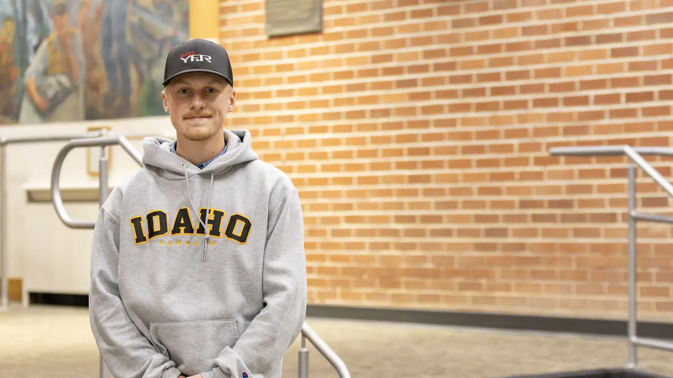 Tucker Hansen stands inside of a campus building.