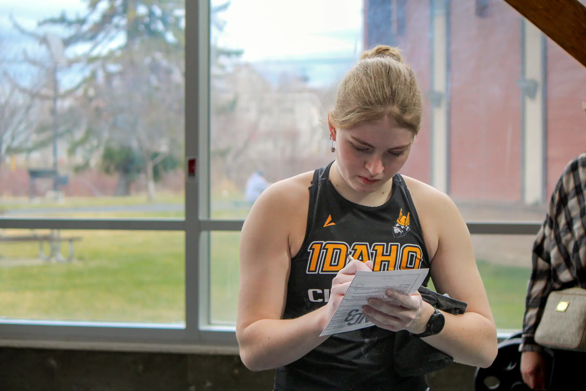 A female climber writing down climb stats. 