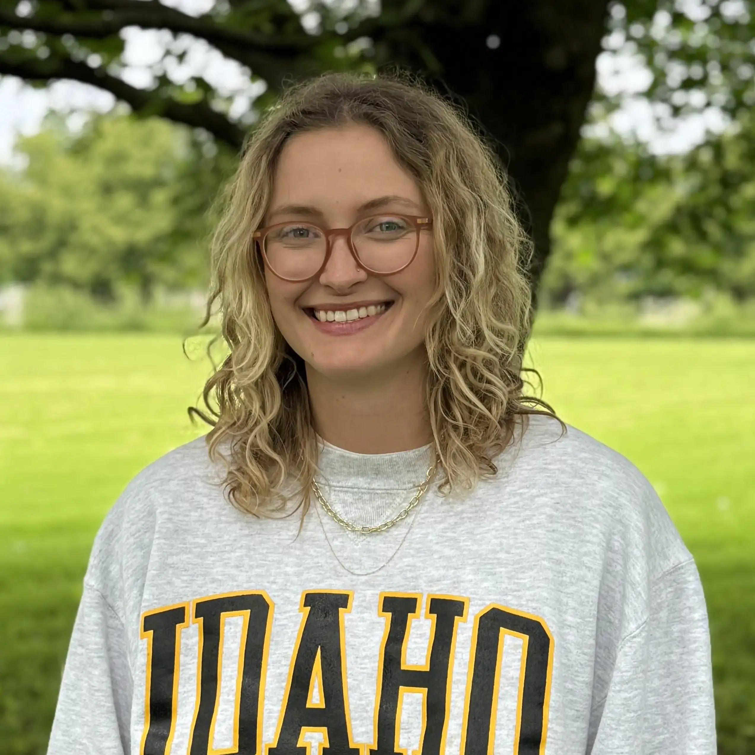 A woman smiling while wearing an "IDAHO" sweatshirt.