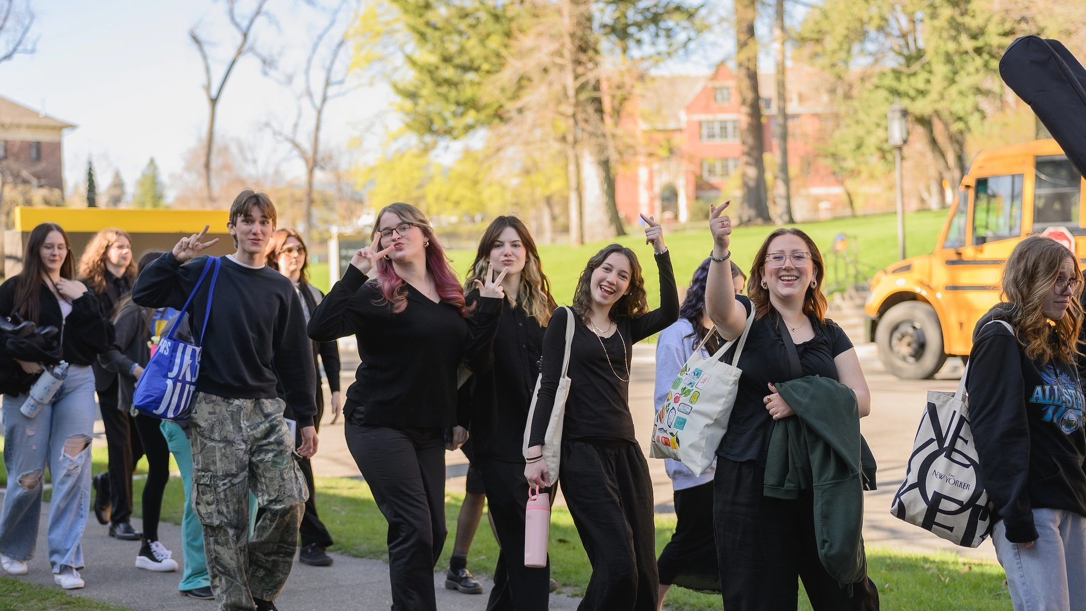 Students walking, smiling and waving at camera