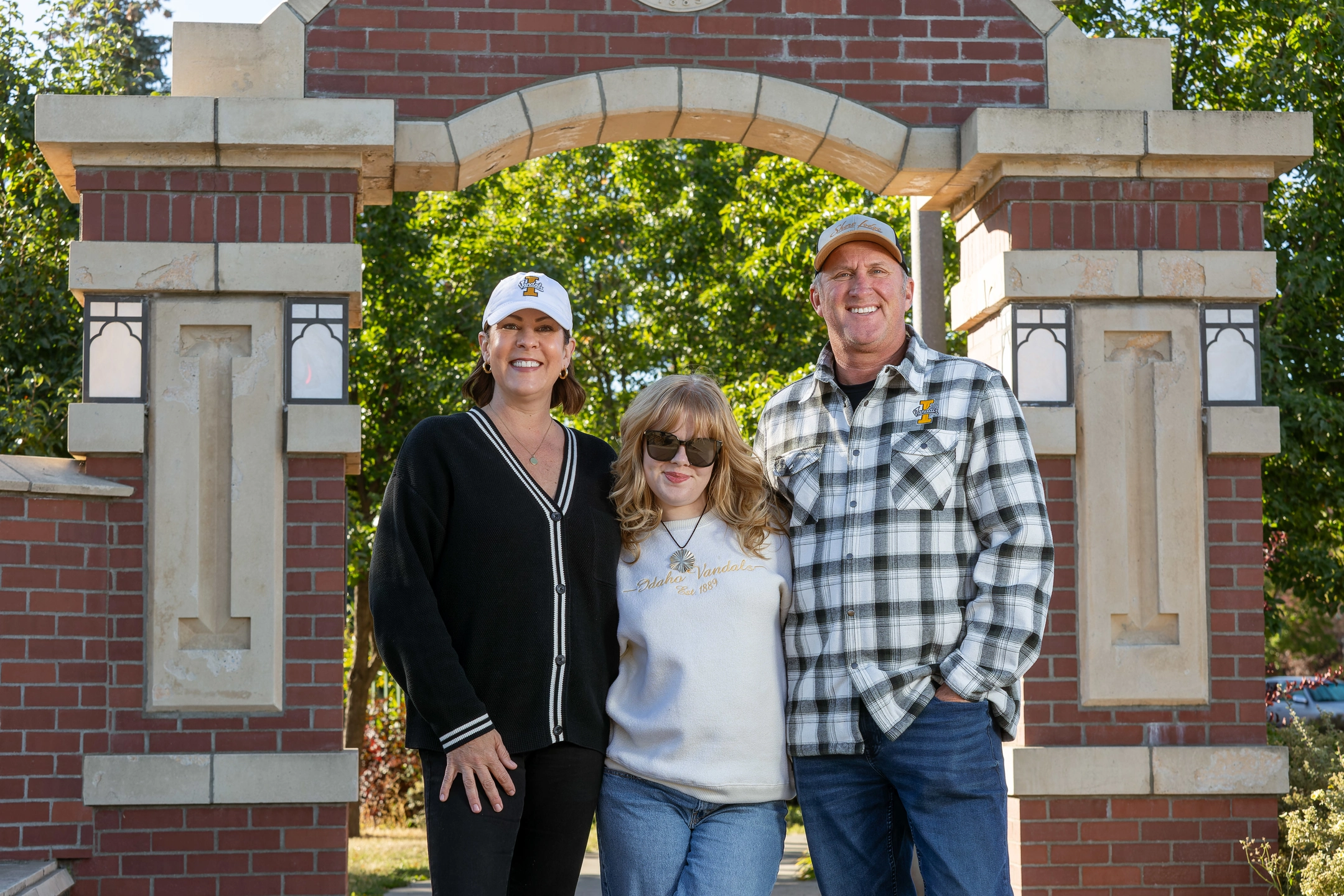 Teresa, Jenna and Kevin Partington pose as a  family at the entrance to University of Idaho.