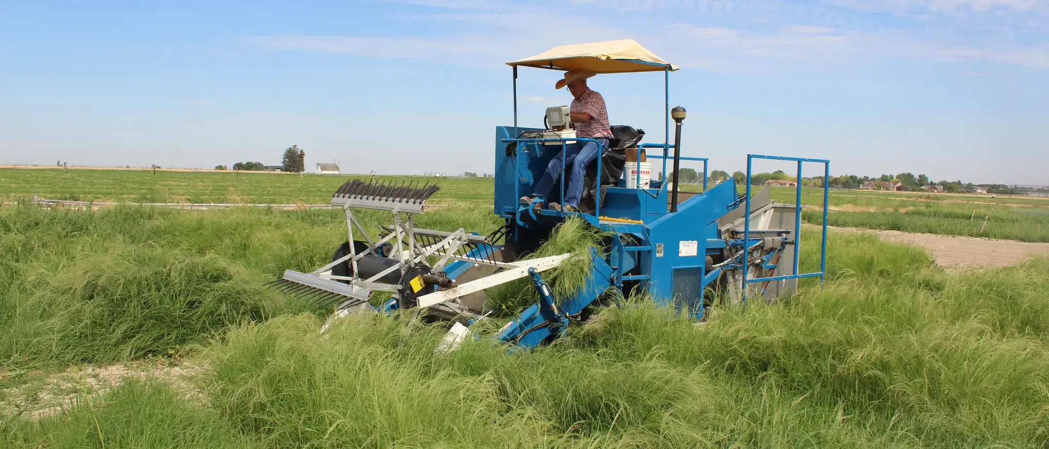 Person sits in farm equipment in a field