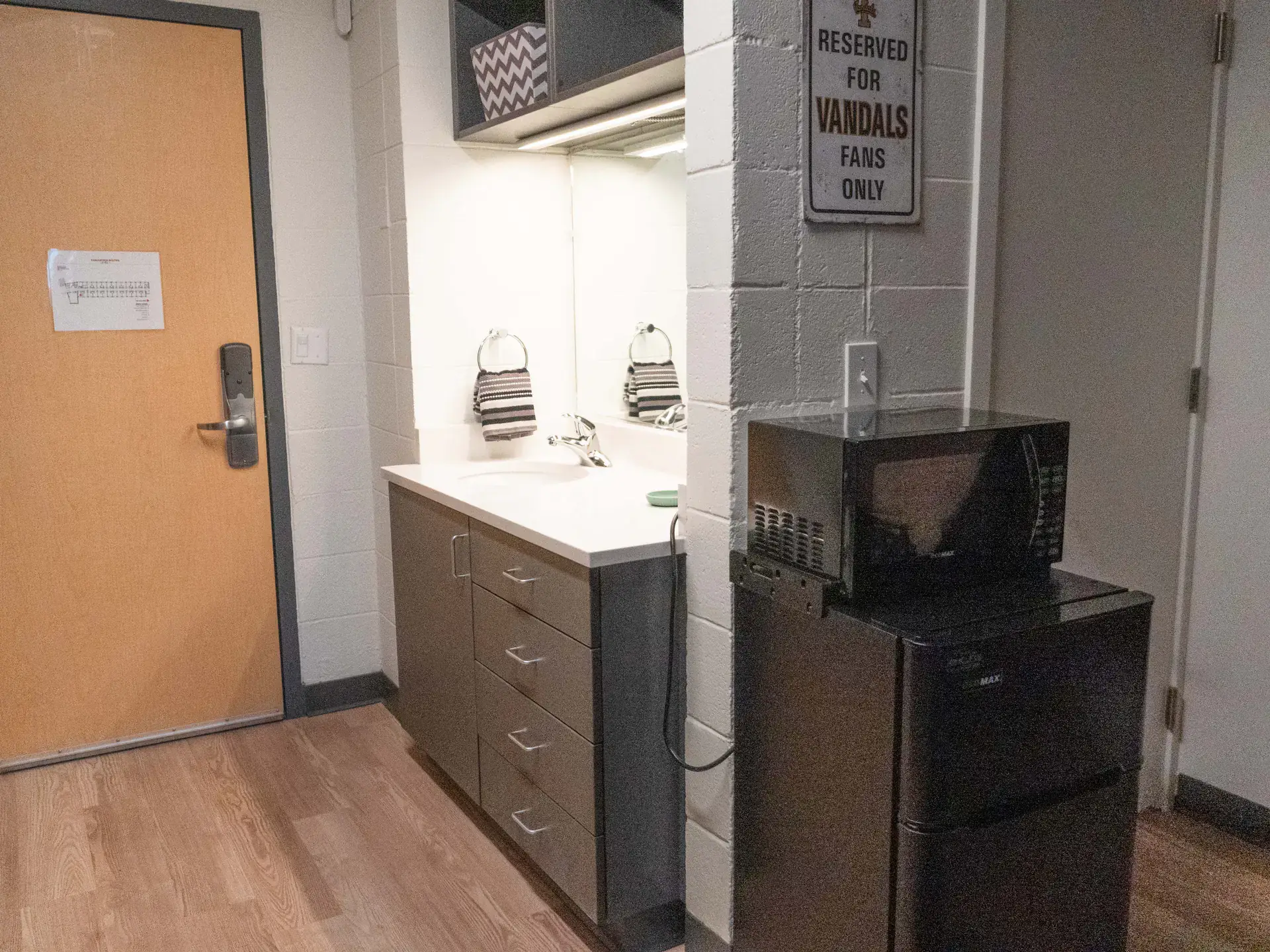 The renovated dorm room's sink and mini fridge.