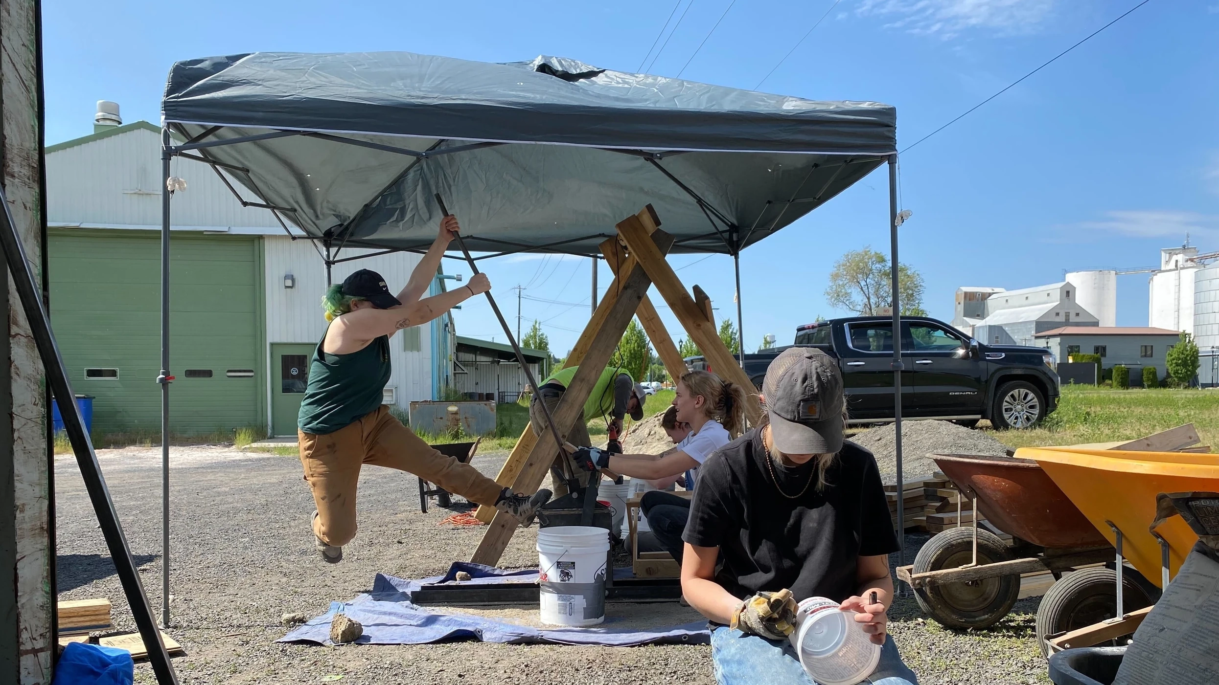 Photo of students under pop up tent making bricks