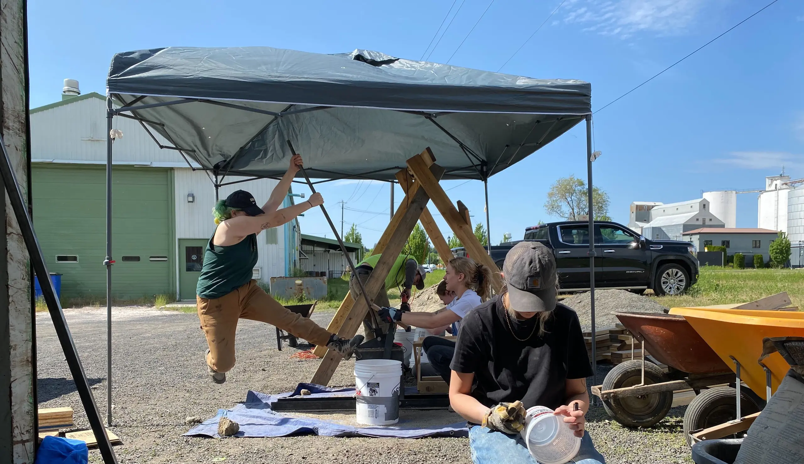 Photo of students under pop up tent making bricks