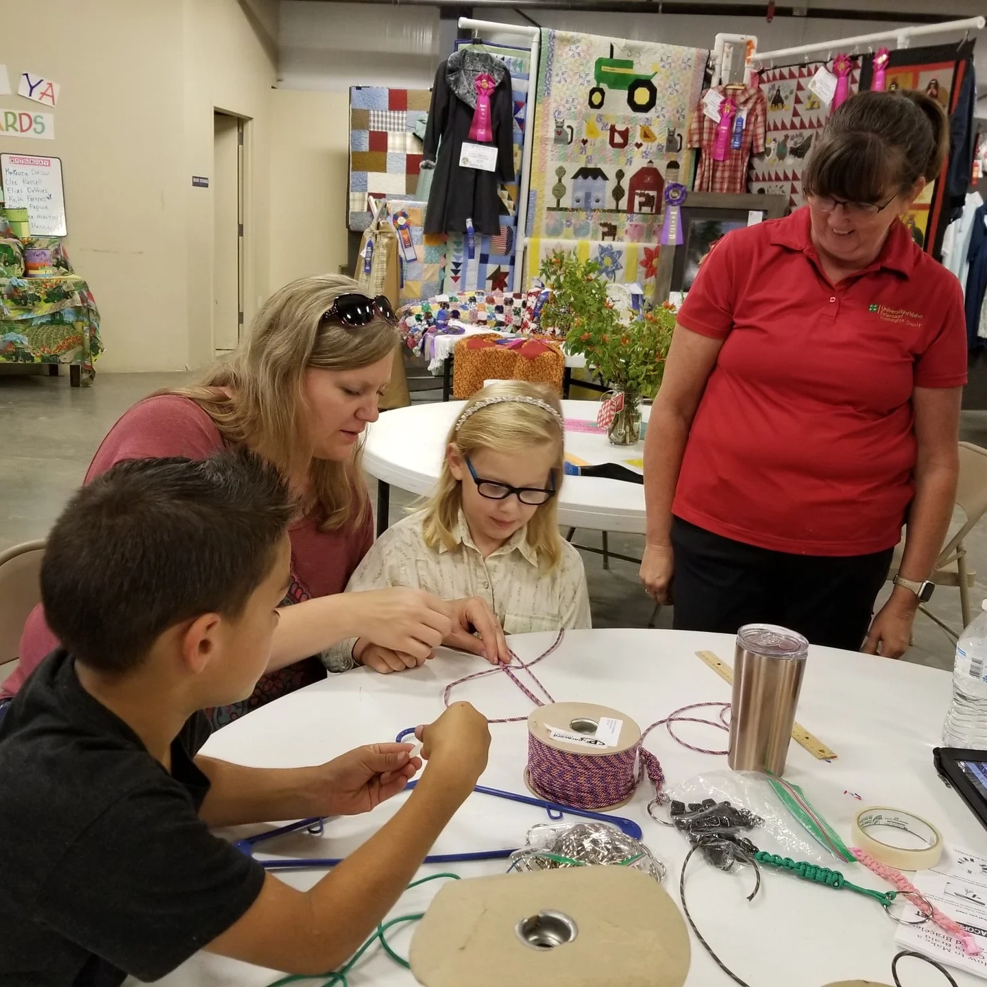 Adults and children do crafts around table.