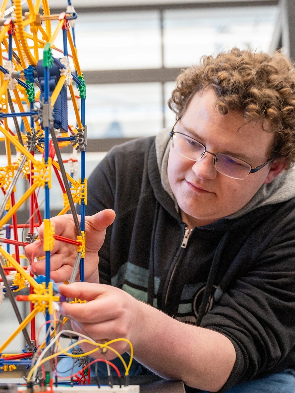 A man works on a miniature Ferris wheel.
