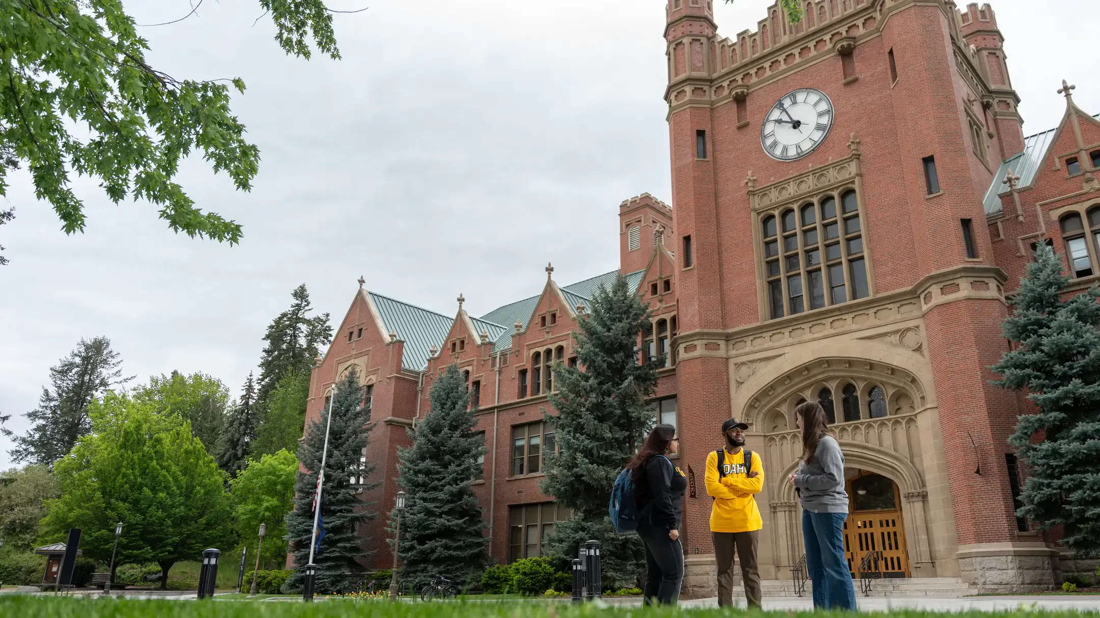 Students in Vandal gear linger in front of the U of I Administration Building on a fall afternoon
