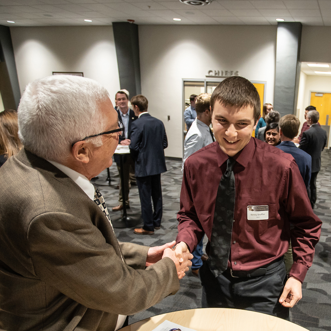 Engineering student shakes hand with employer