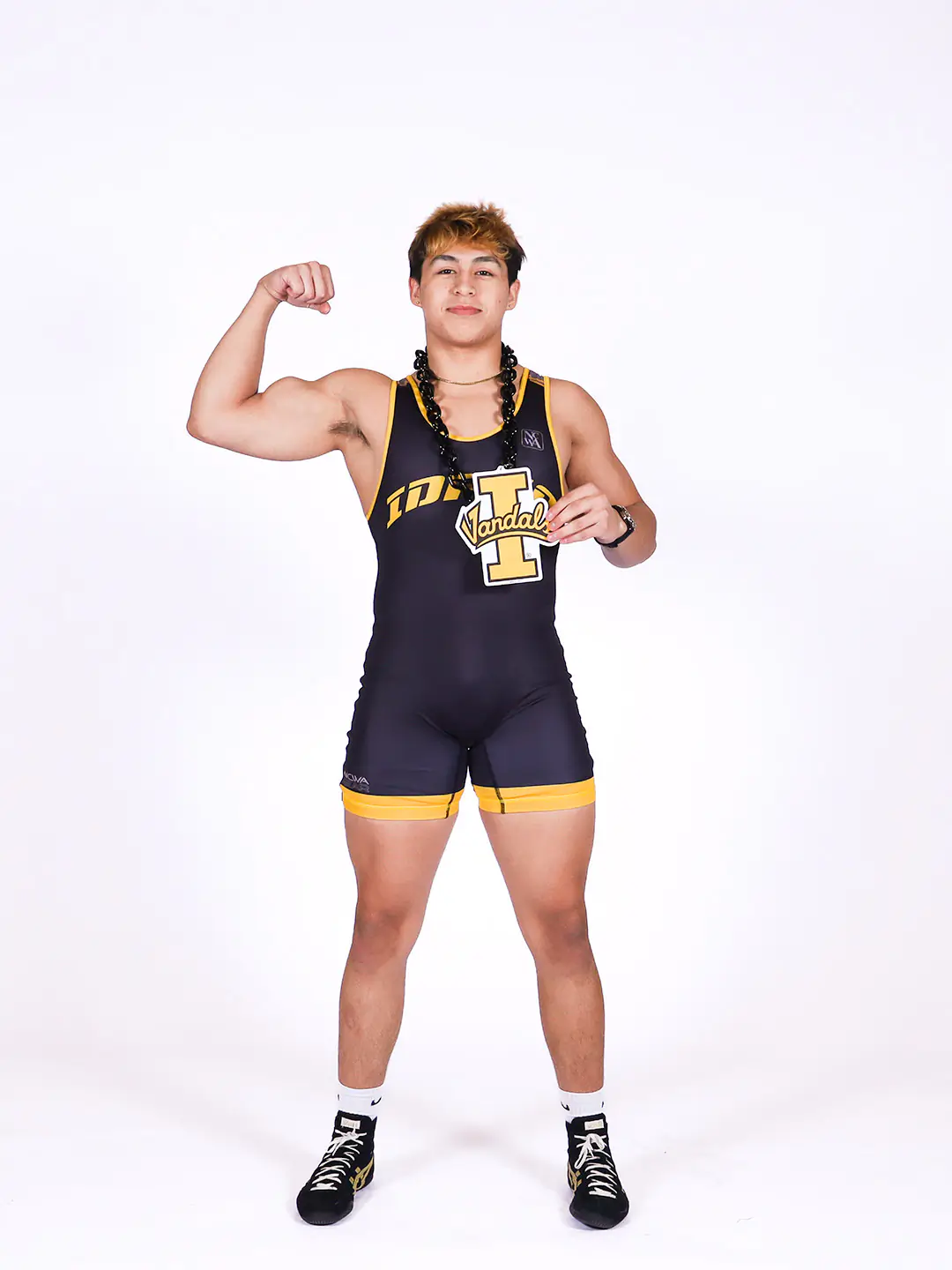 James Greene posing with one arm up in a bicep flex, wearing his wrestling uniform.