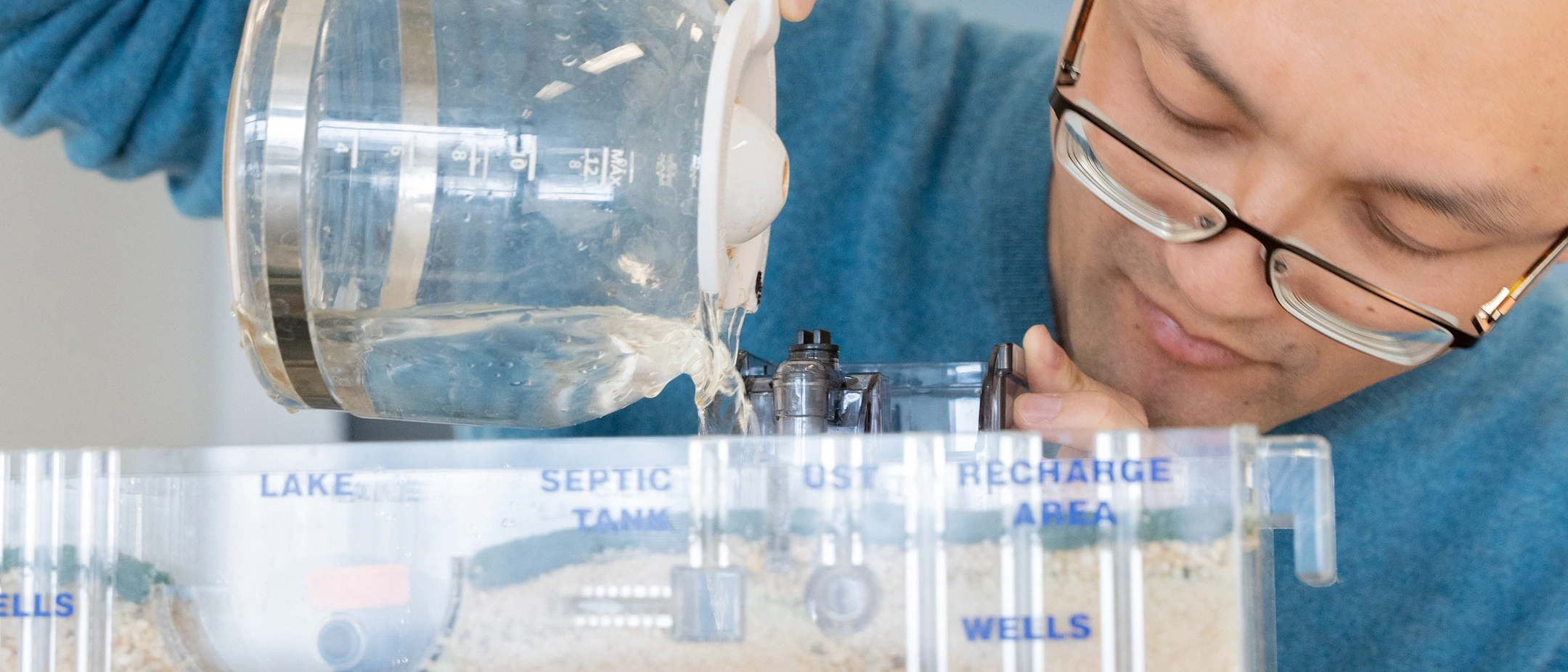 Ӱֱ Earth and Spatial Sciences assistant professor  Meng Zhao studies how trees use water in relationship to how much water is Ӱֱ to human beings in relationship with climate change. Here, he is demonstrating a Sand and Gravel ground water Simulator.