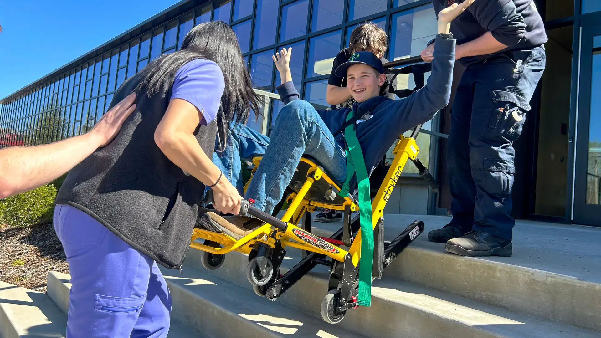 group of people using a stryker stair pro to assist seated person on stairs