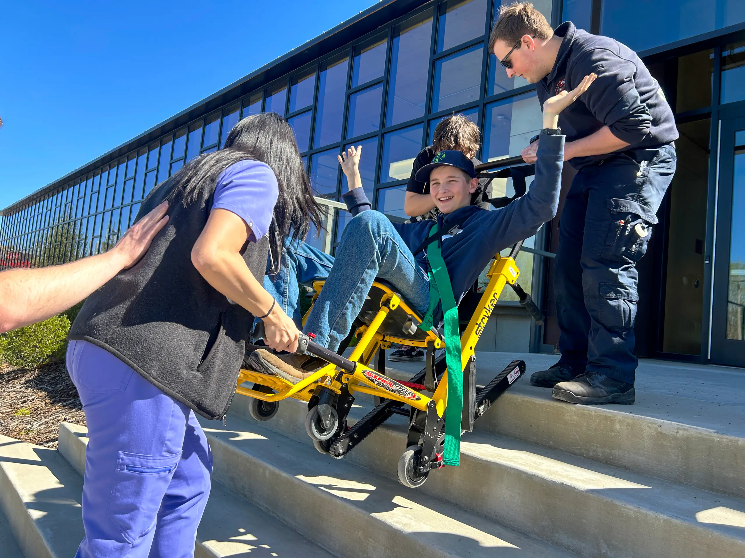 group of people using a stryker stair pro to assist seated person on stairs