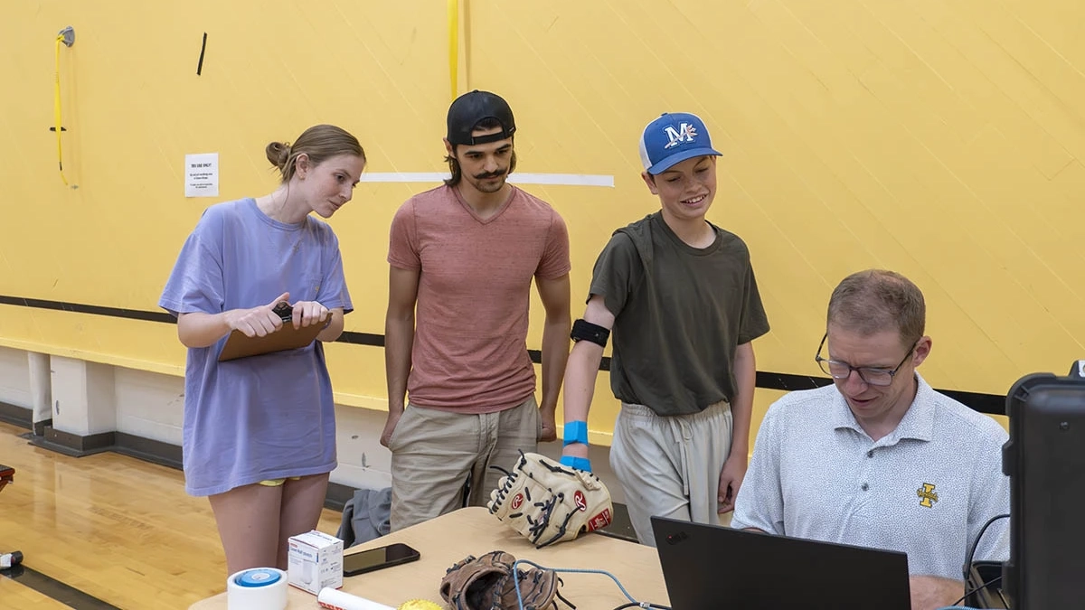Four people looking at computer screen. 