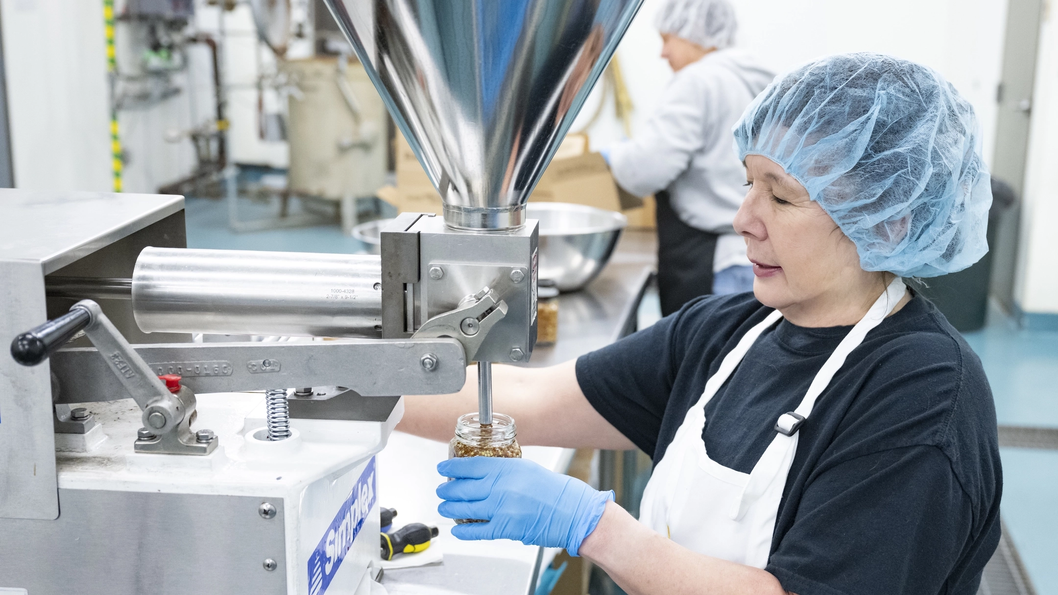 A user of the Food Technology Center fills a jar with Wagner’s mustard.