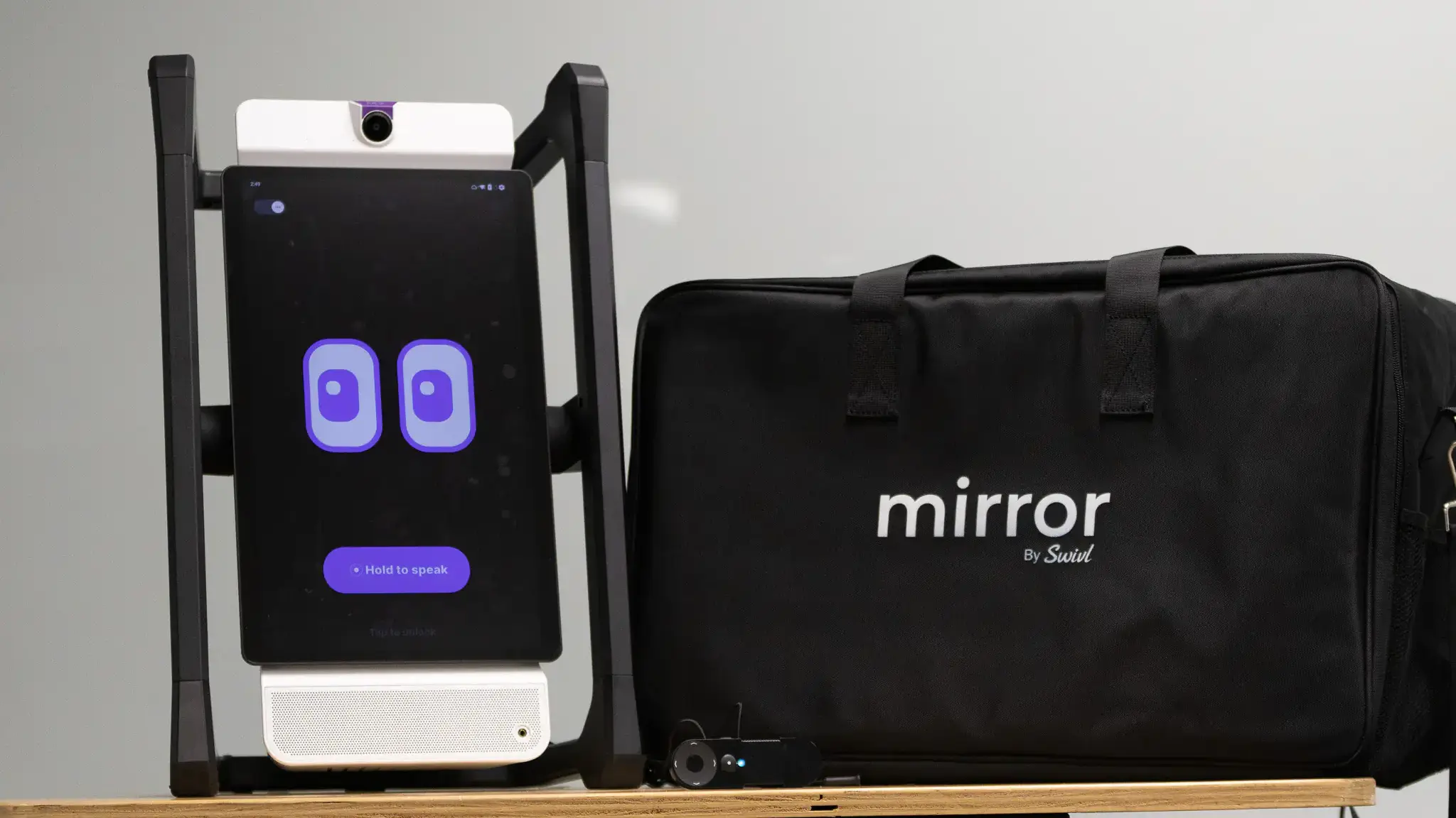 A robot with a digital readout screen containing blinking eyes is displayed by its case