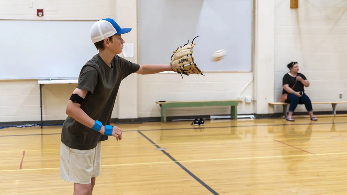 Young boy catching baseball.