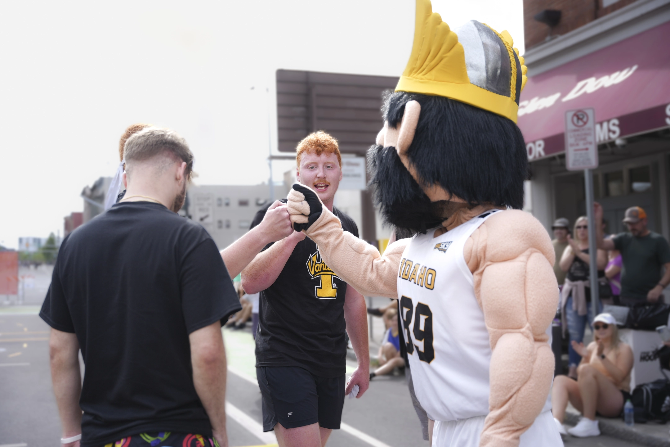 Ryan Collins and teammates Evan Sonka and George Forsmann get fist bumps from Joe Vandal