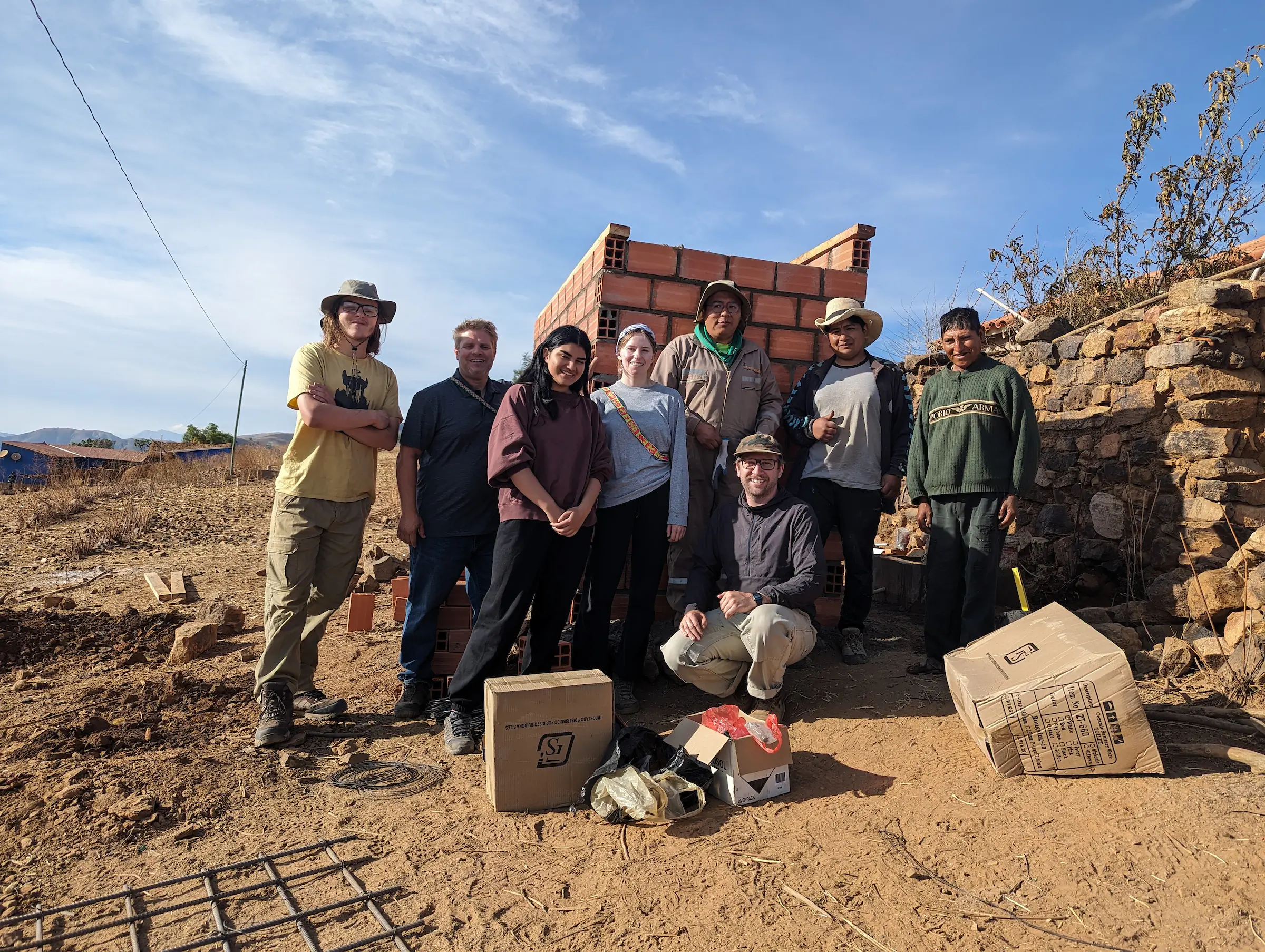 Students pose in front of a brick structure