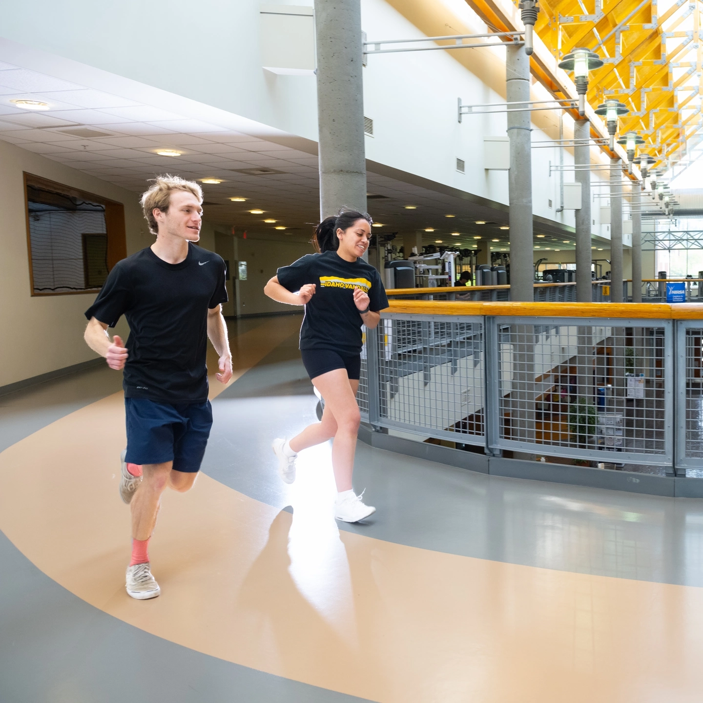 Two students run on the indoor track in the Student Recreation Center