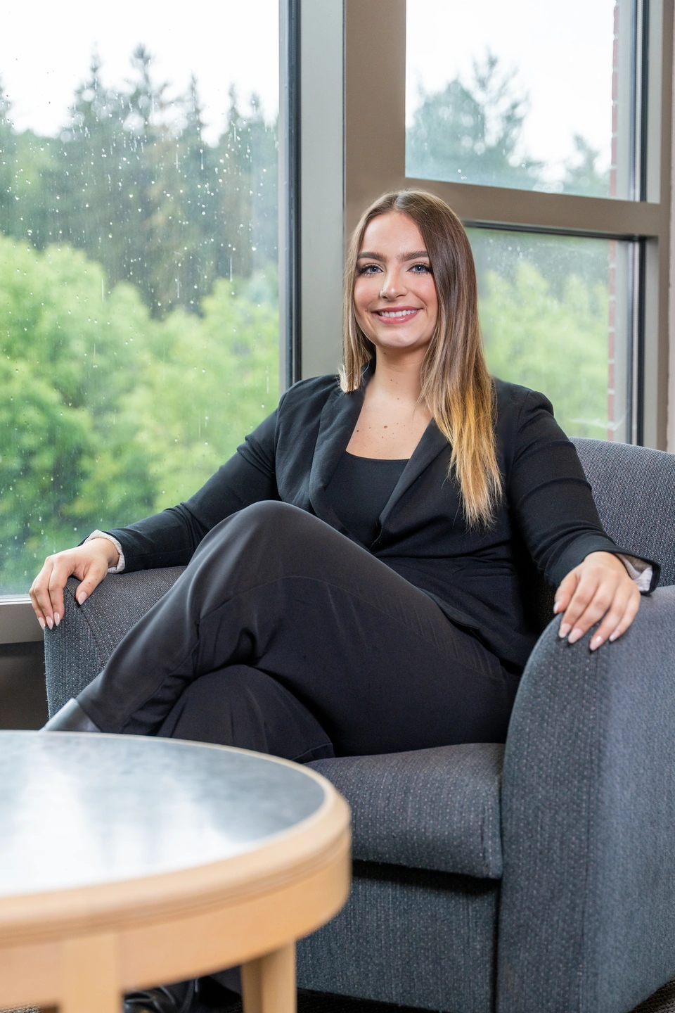 Anna Bliss, dressed in black, sits in a chair
