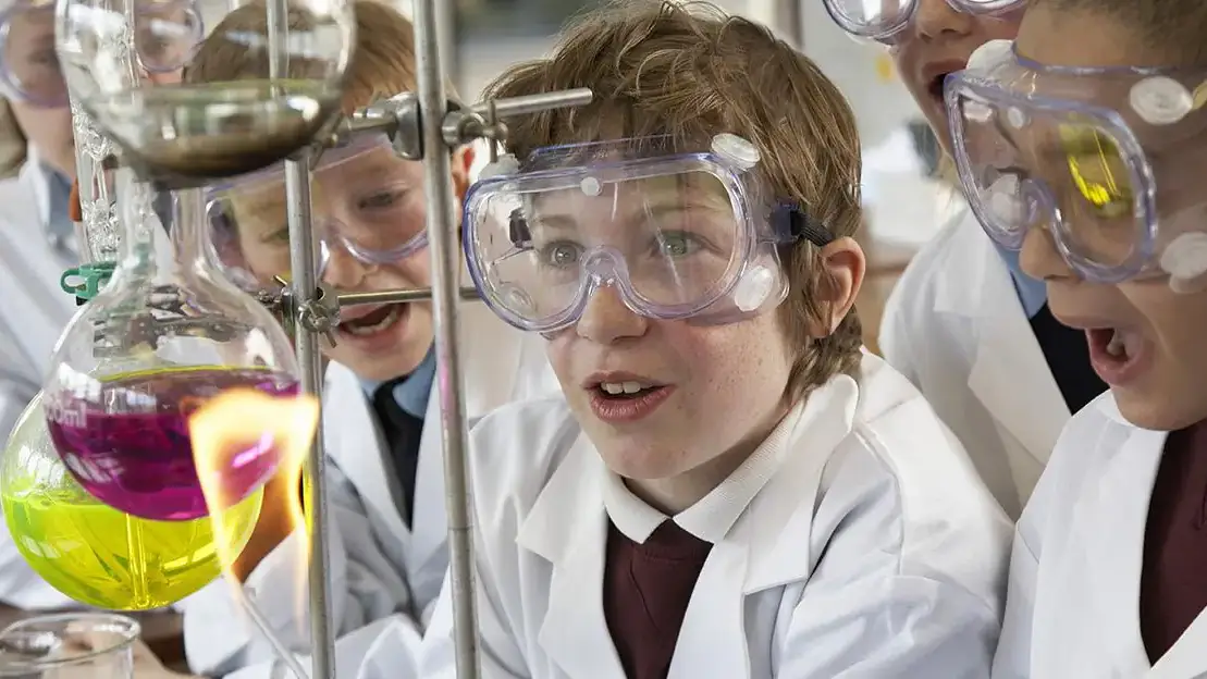 Children in lab coats and goggles having fun with bunsen burners at Vandal Science Day