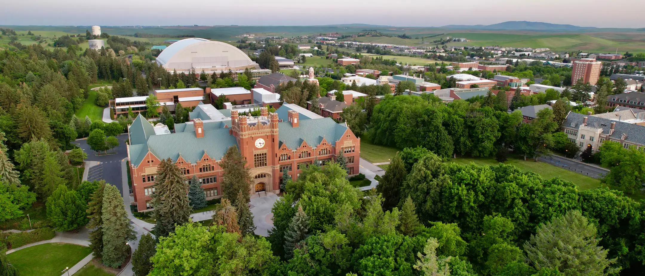 An oblique aerial view drone photograph of the University of Idaho Administration Building and campus in the spring.