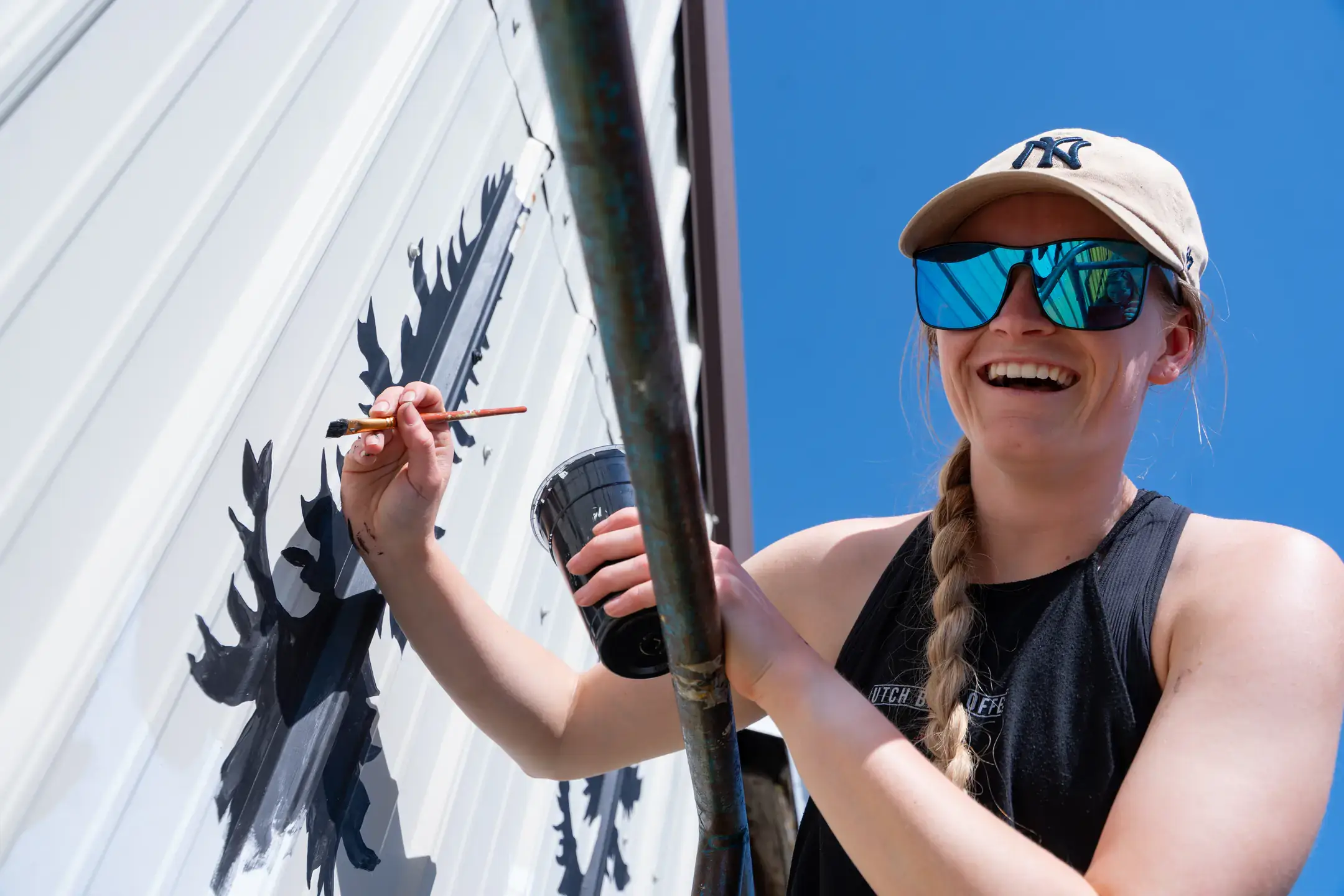 Alumna Mikaela Herrick paints a University of Idaho mural on the south wall of Forty Two bar and kitchen restaurant in Moscow, ID Thursday, April 24, 2025.