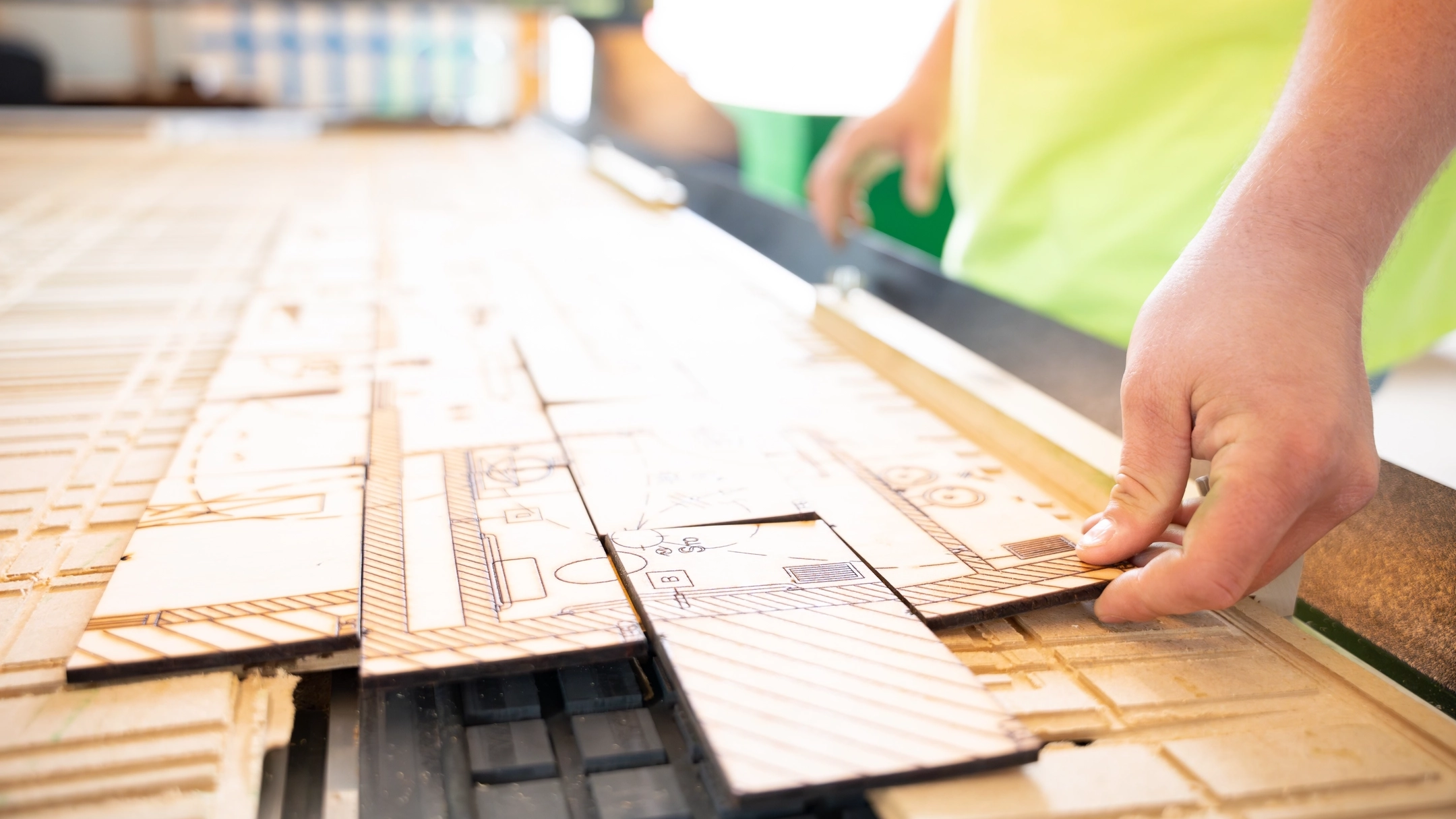 A man placing lego-like wood pieces together with house designs engraved in it