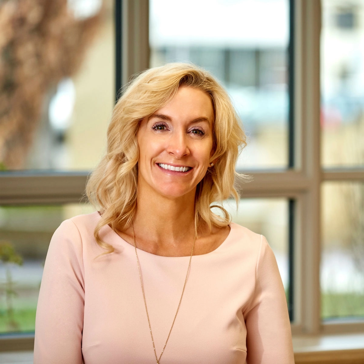 A woman professionally dressed smiling at the camera