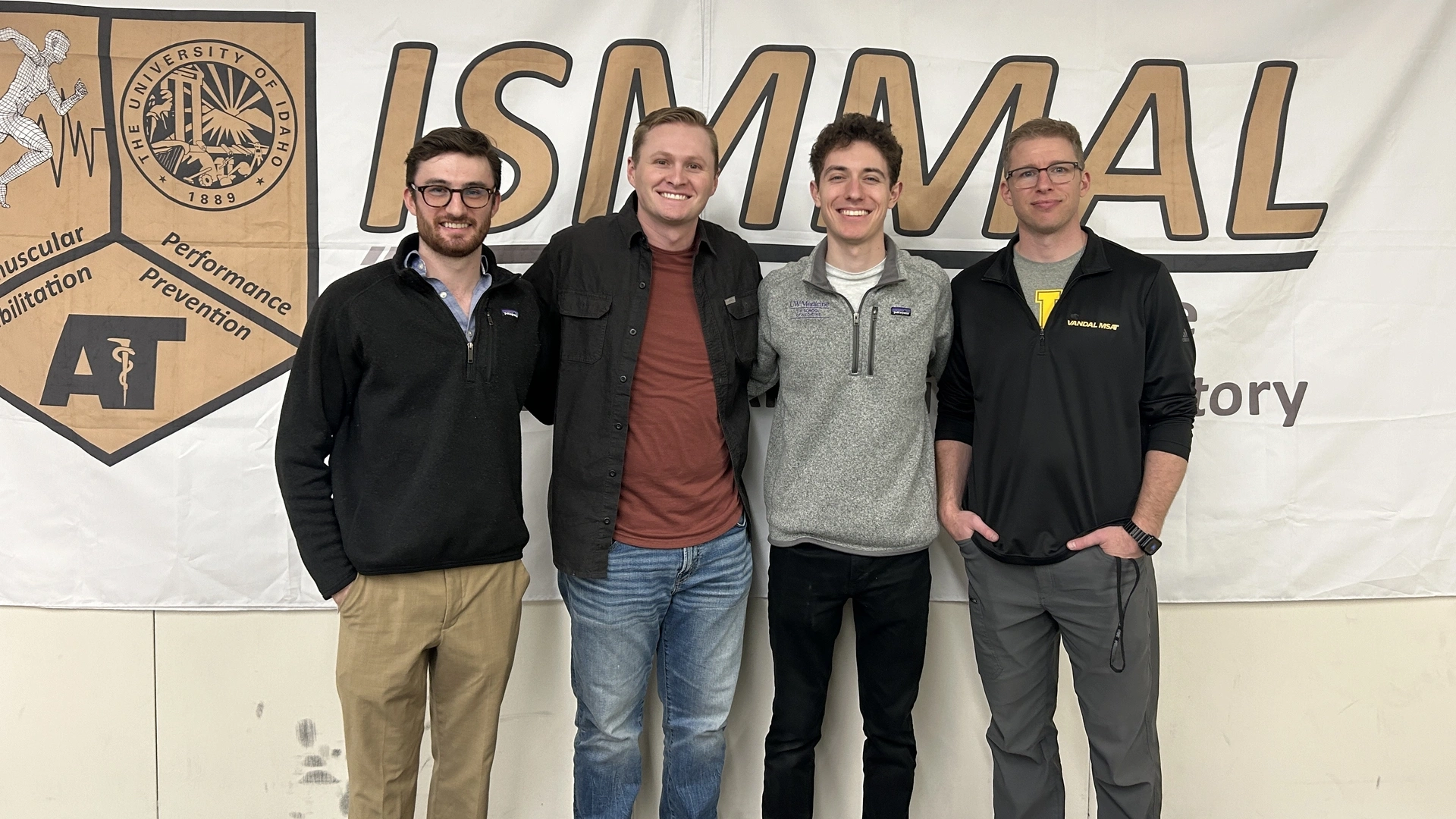 group of students pose in front of ISMMAL banner