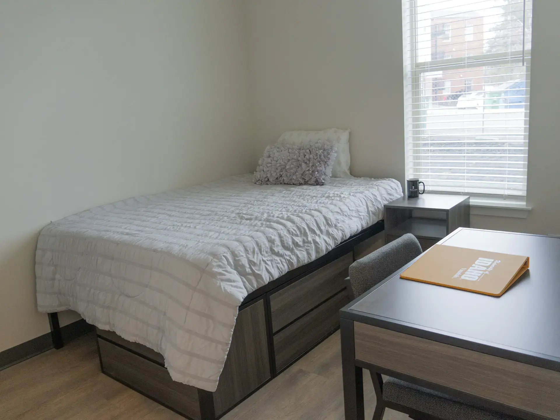A bedroom with a desk and a bed.