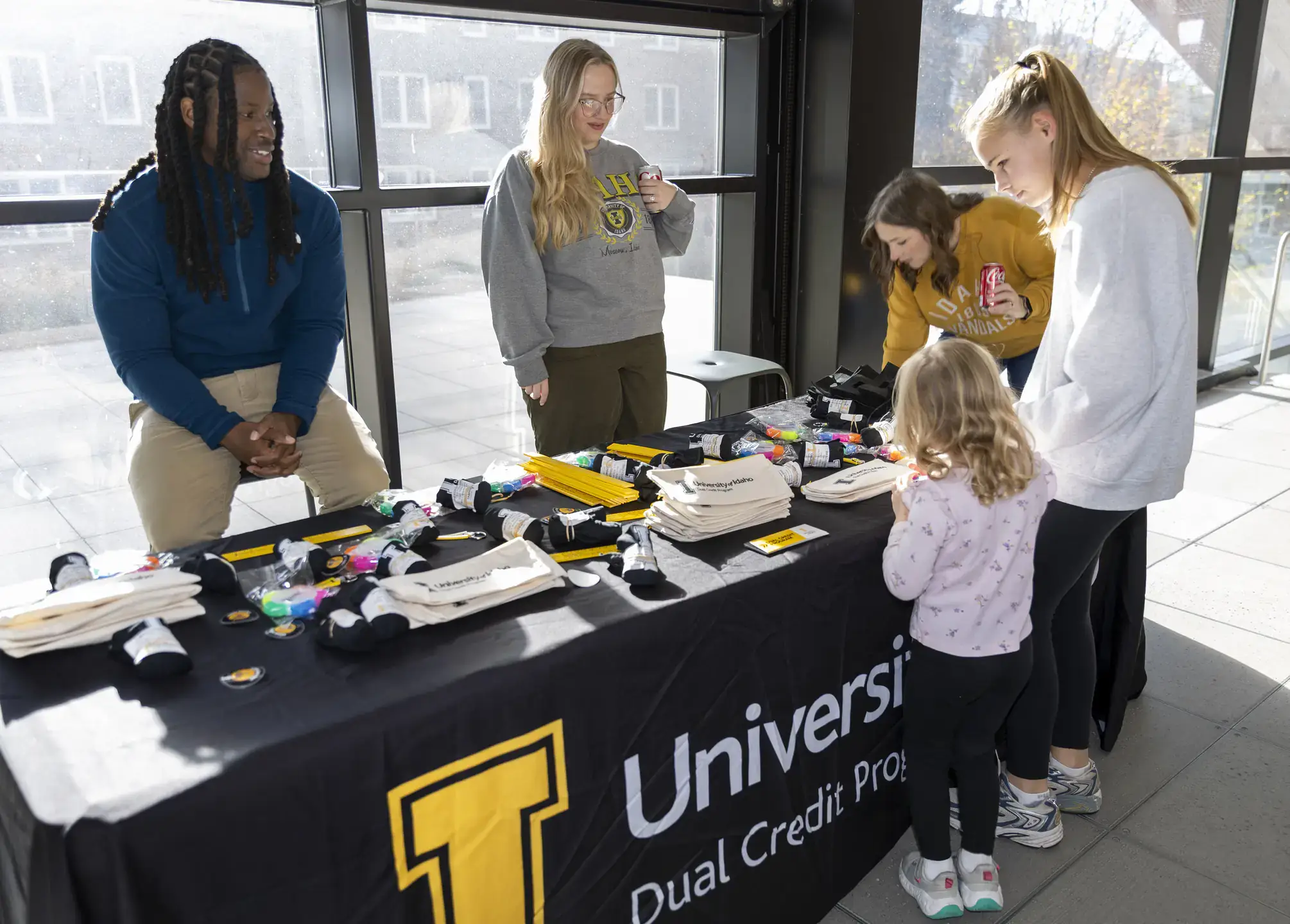 Lorenzo Rene working at a UIdaho recruitment table for the dual credit program