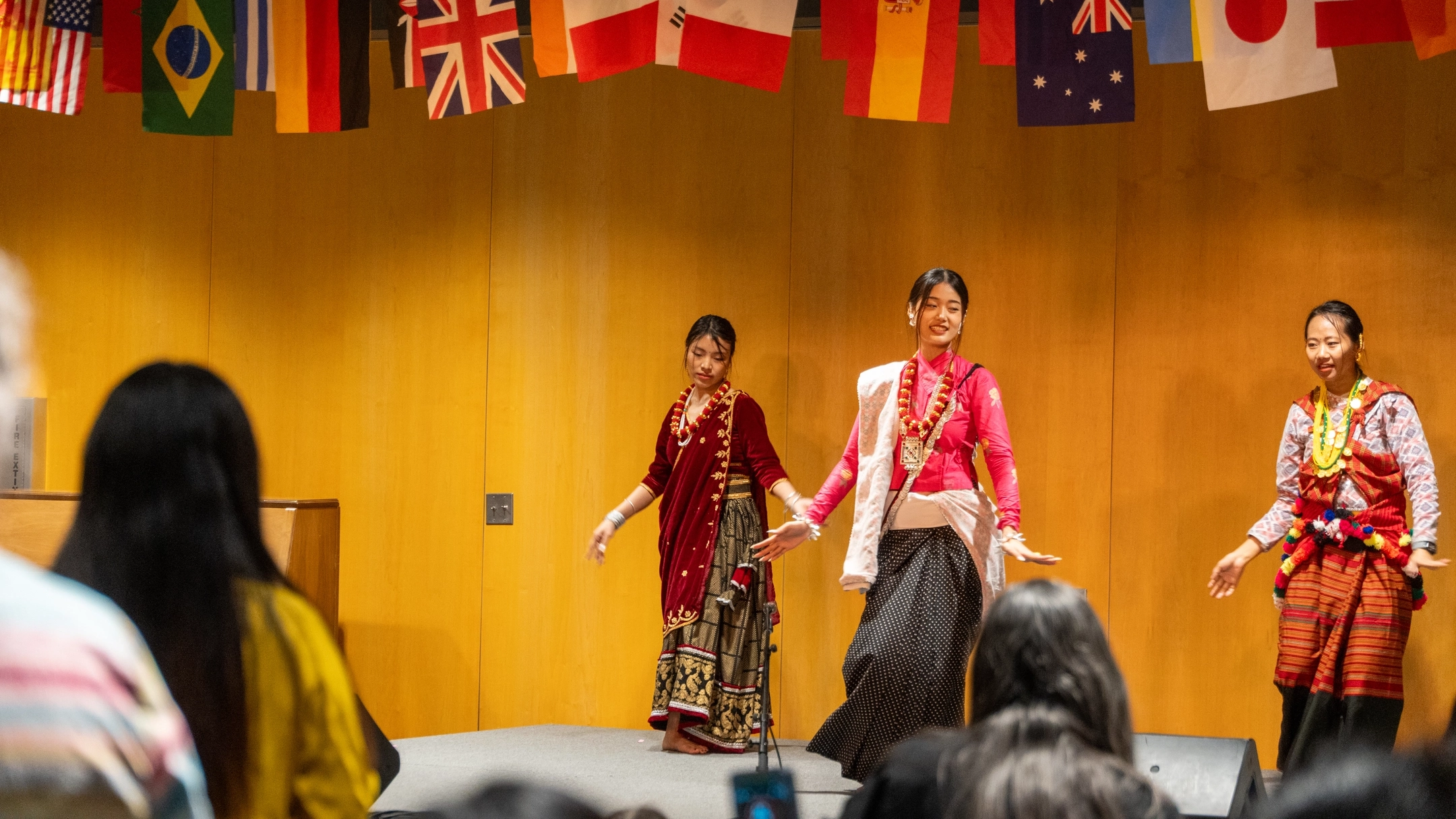 People perform on stage while wearing cultural attire