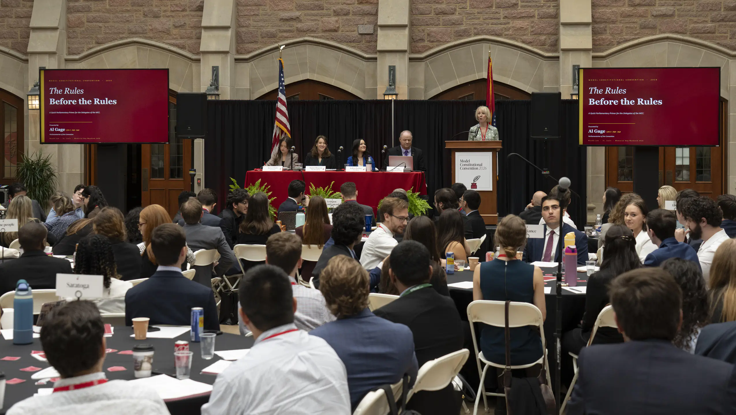 A convention hall of Law students facing an elevated table and podium of student leaders and professors.