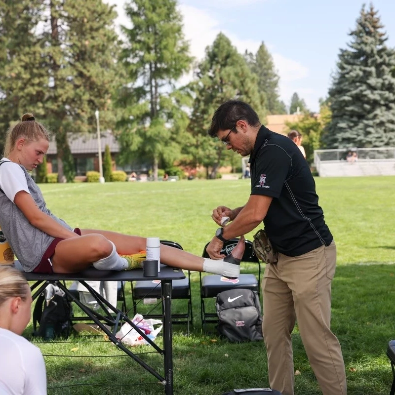 Man treating injury to woman lying on a table
