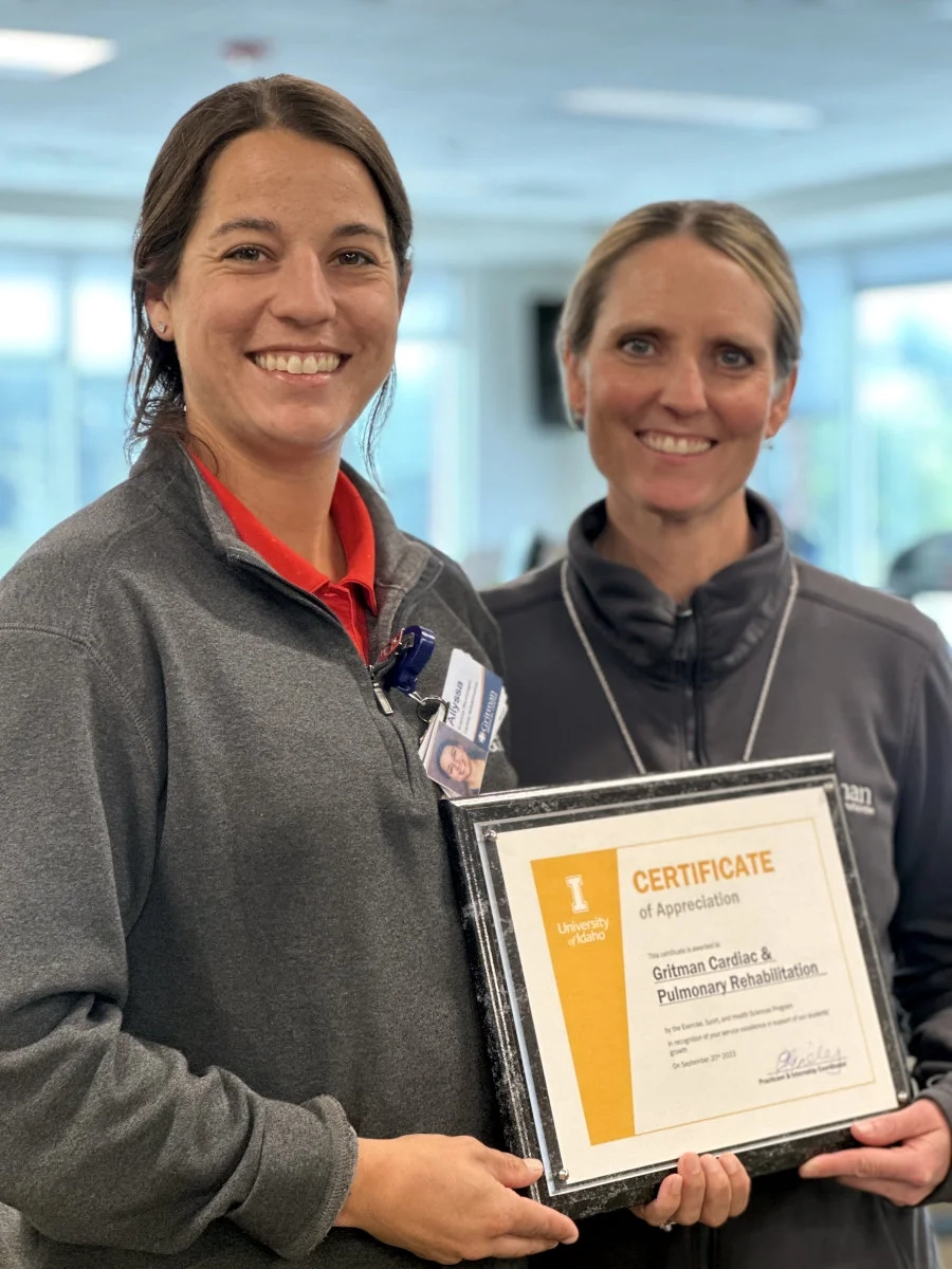 Left to right, Kristi Holden and Allyssa Loesch holding a framed award.