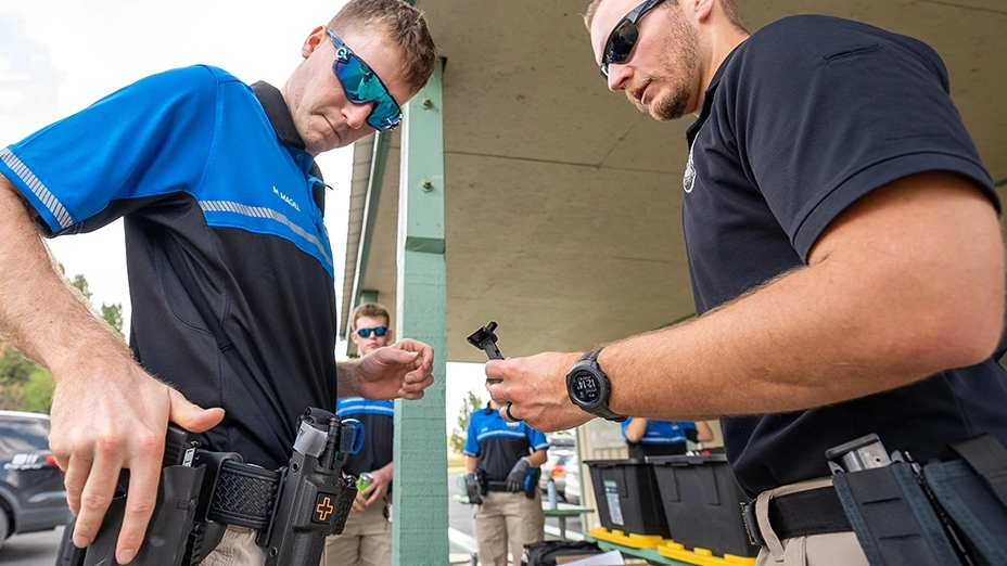 A police department employee supervises a holster