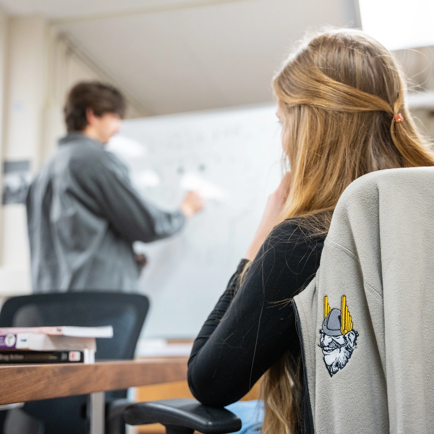 Graduate student Wade Scott at a white board in the Department of Psychology and Communications collaborates with student Katelynn Kjorness while researching addictions.