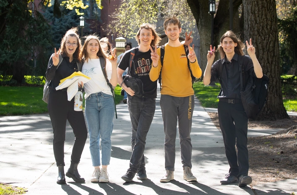 Students on the Administration Building Lawn walkway on the Ӱֱ campus in the spring.