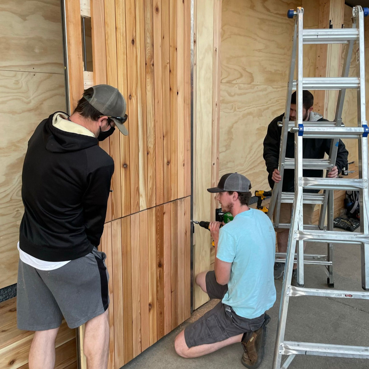 Students drill into pieces of lumber. 