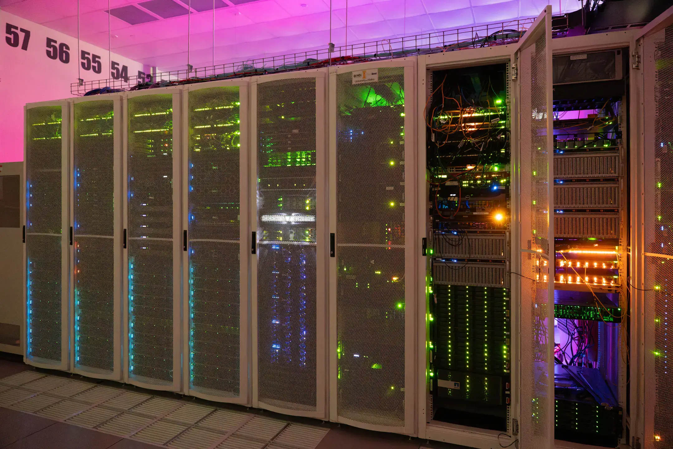 An array of server racks illuminated with colorful lights in a data center at Idaho National Laboratory.