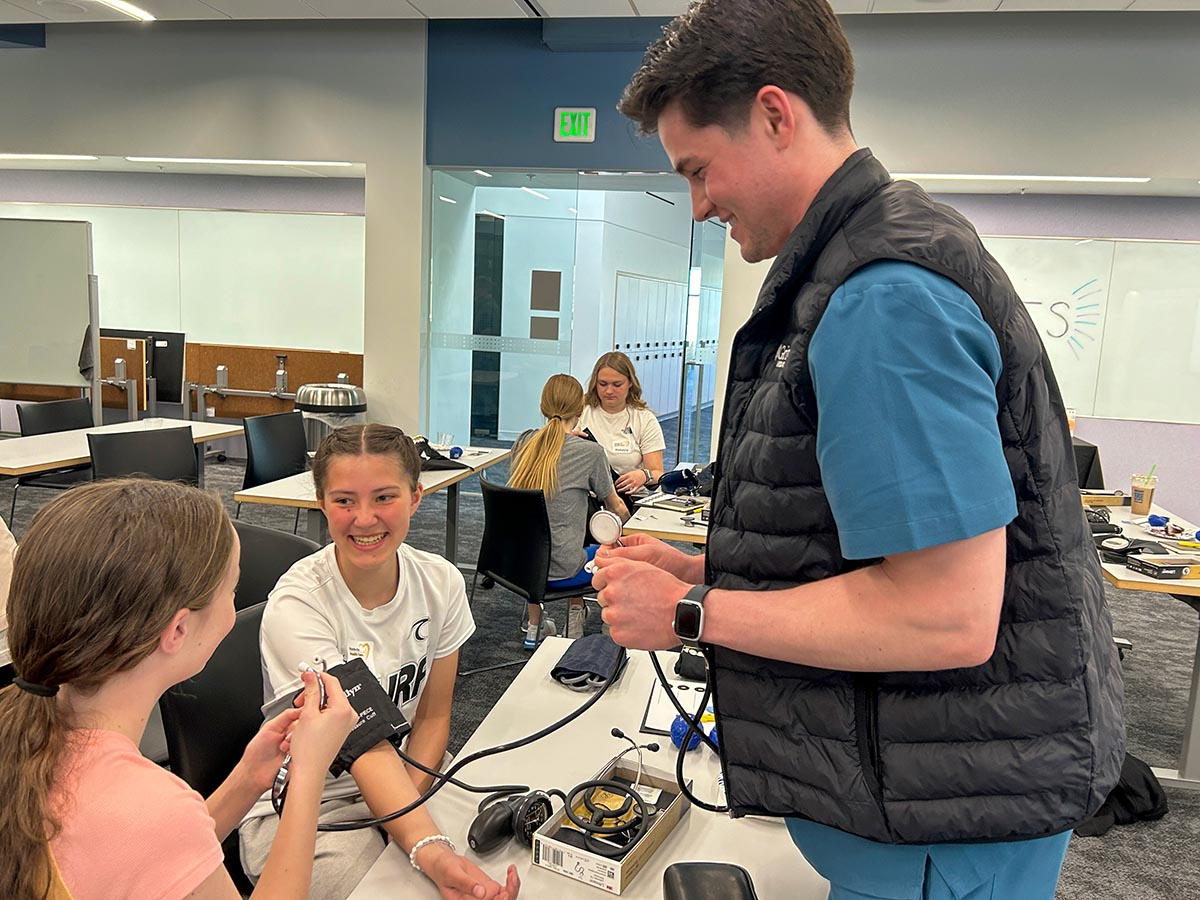 Two girls take each other’s blood pressure.