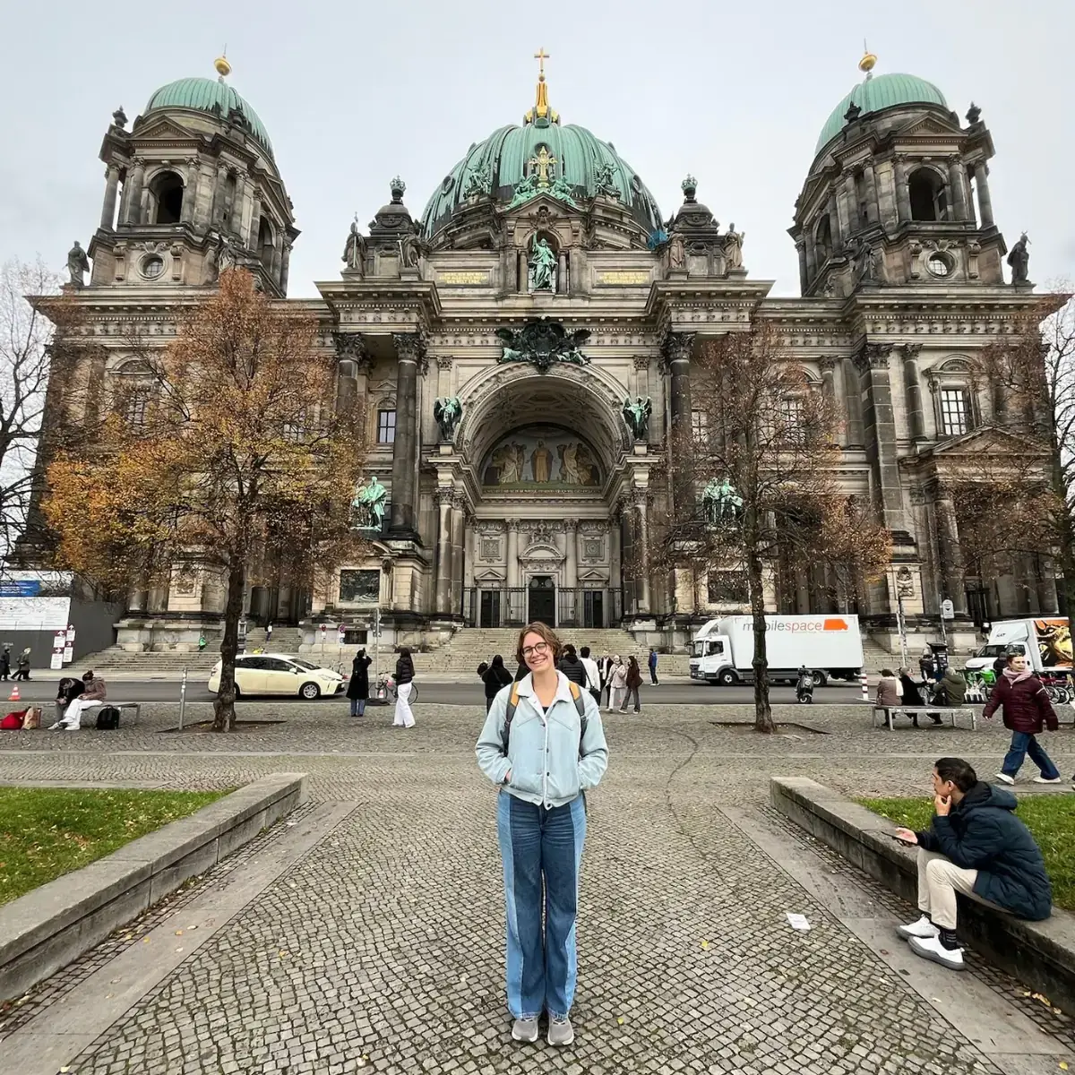 A woman posing in front of a building.