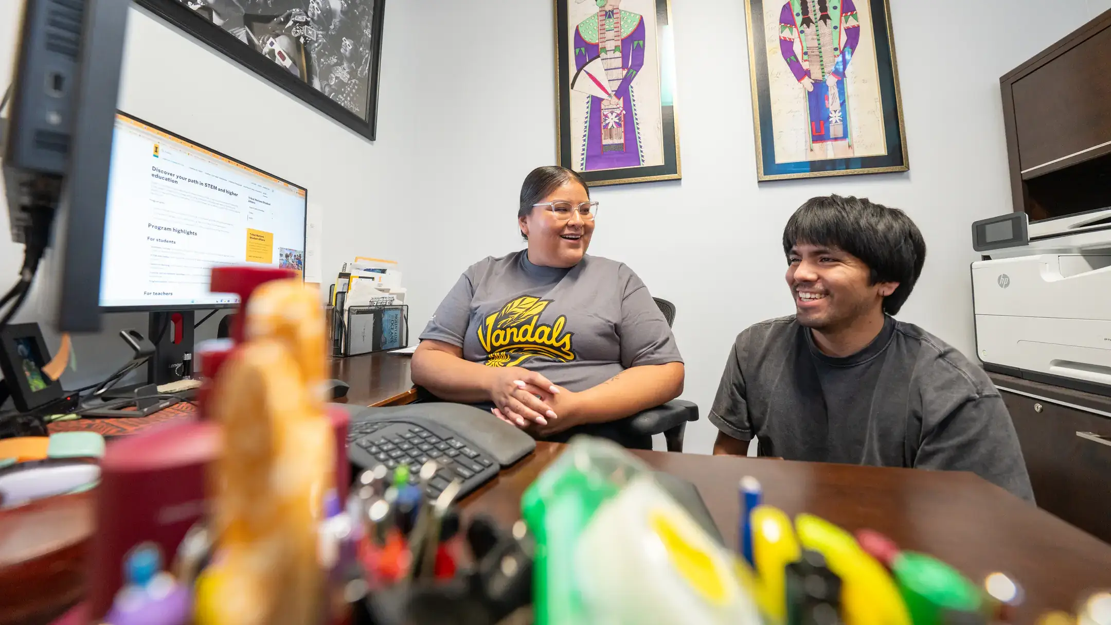 A student and a program coordinator sitting in an office.