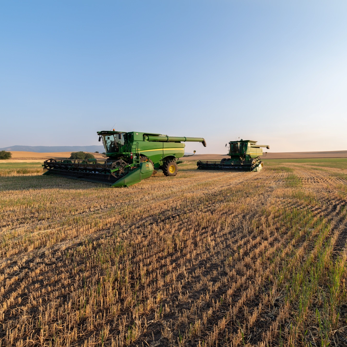 John Deere combines parked in a farm field in Idaho, USA