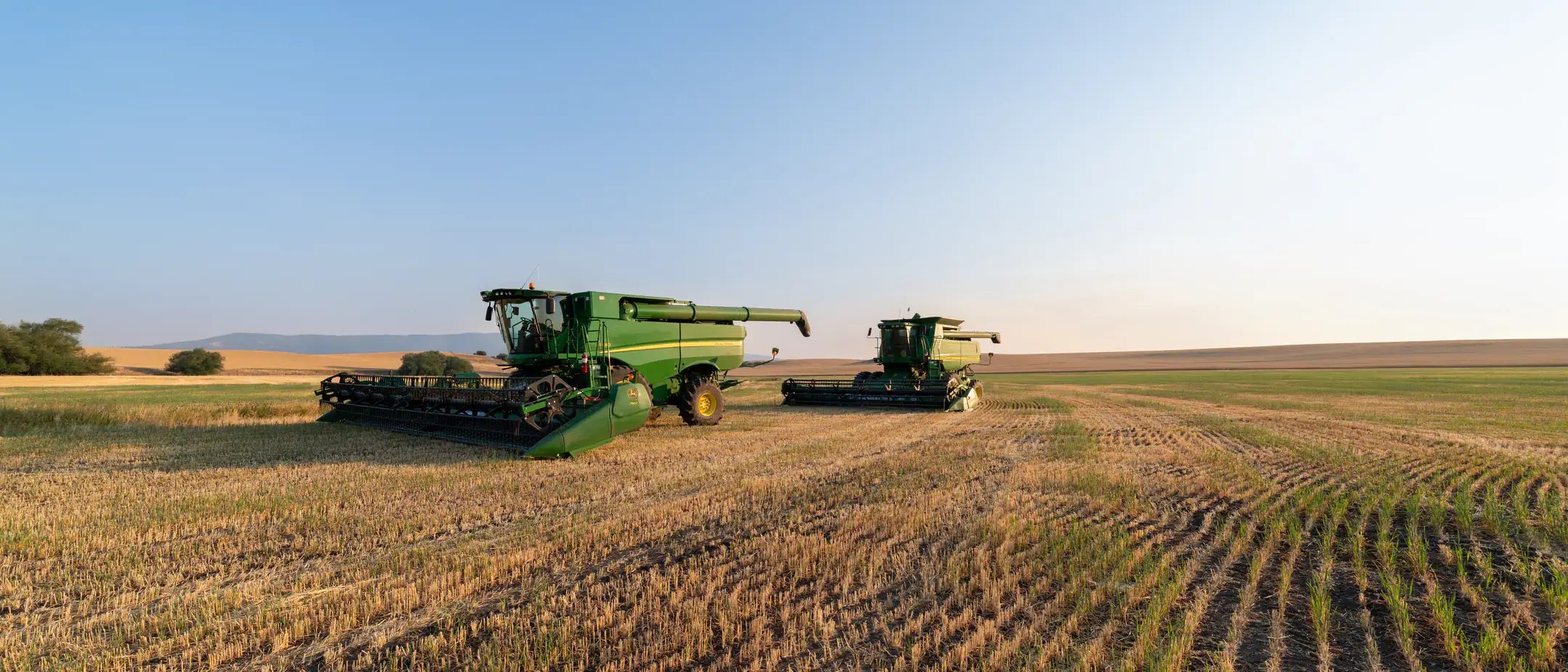 John Deere combines parked in a farm field in Idaho, USA