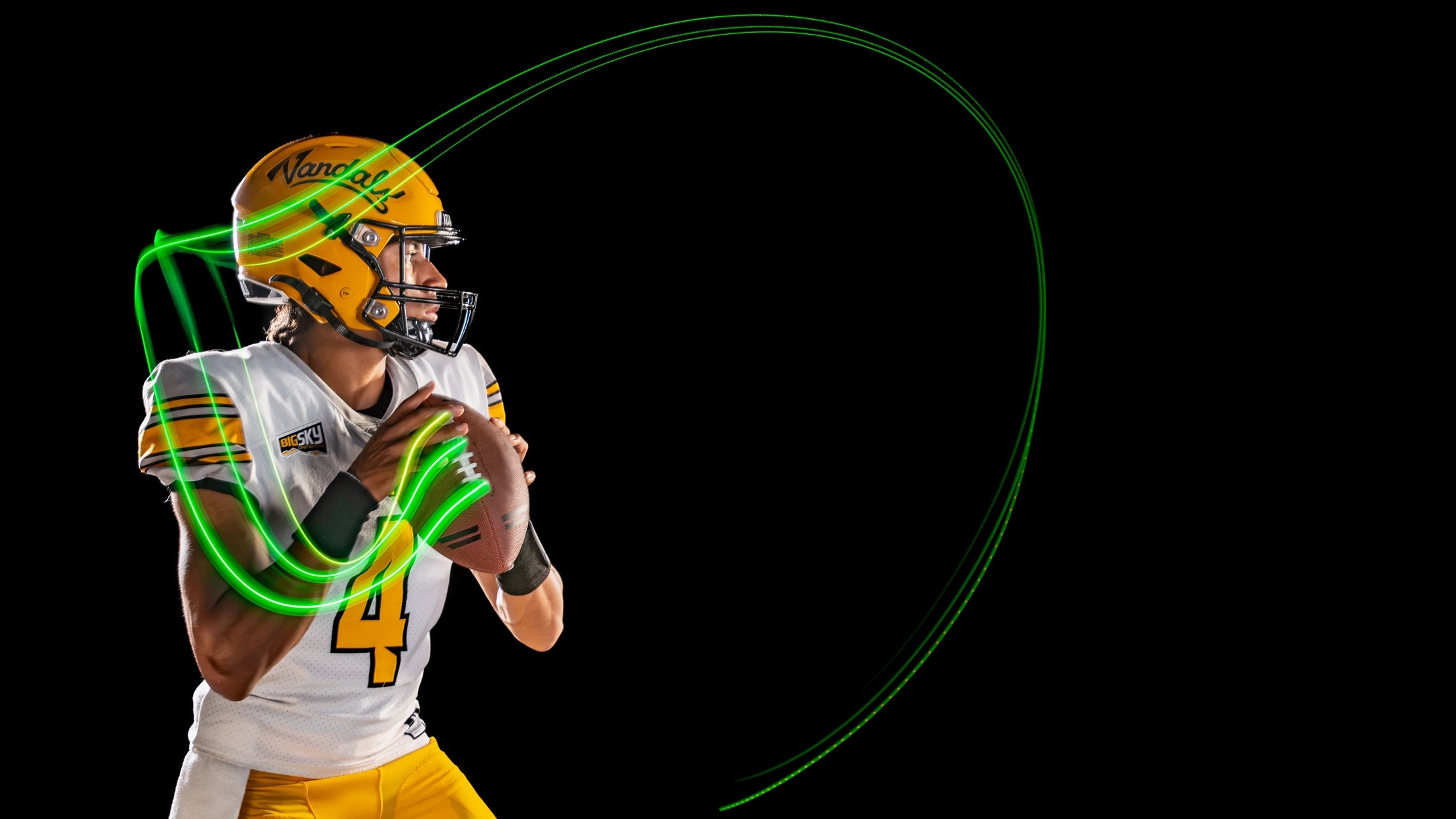 Quarterback throwing football with green light trail