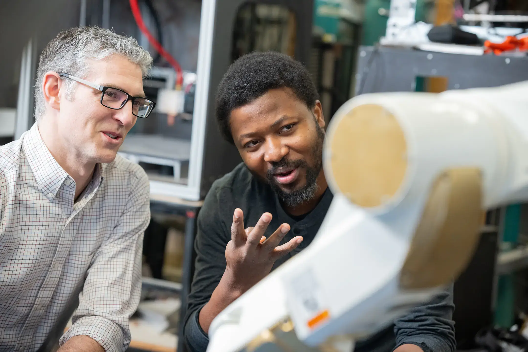 Michael Maughan and Senami Hodonu work on the wood resin mixer and extruder for the interdisciplinary 3D printed house project.